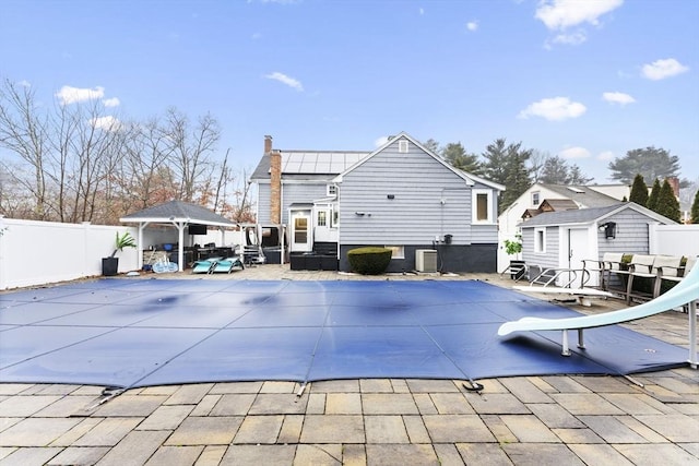 view of swimming pool featuring a gazebo, a patio area, a shed, and a water slide