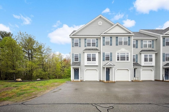 multi unit property featuring asphalt driveway and a garage