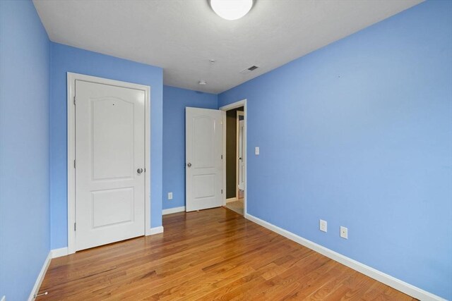 unfurnished bedroom with baseboards and light wood finished floors