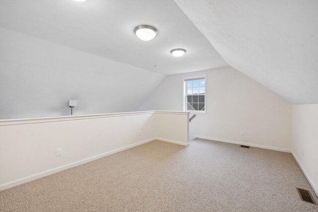 bonus room featuring carpet, vaulted ceiling, and baseboards
