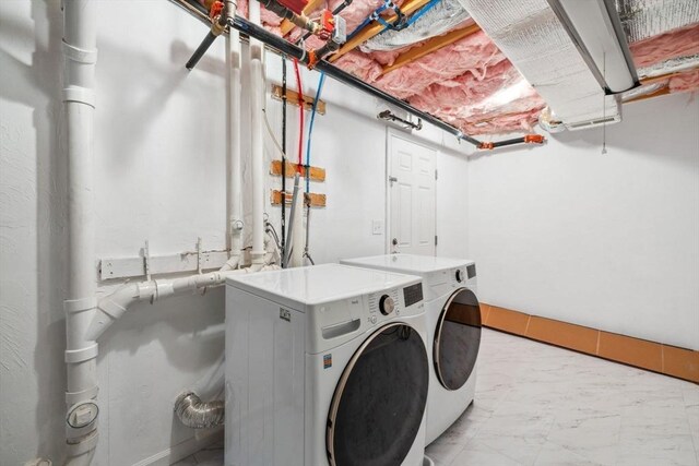 clothes washing area featuring washing machine and clothes dryer and light marble finish floors