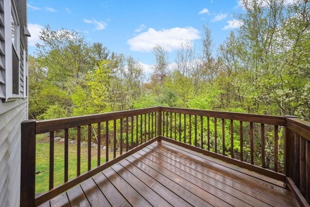 wooden deck with a wooded view