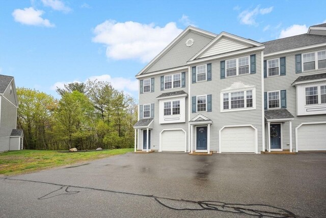 view of property with asphalt driveway and an attached garage