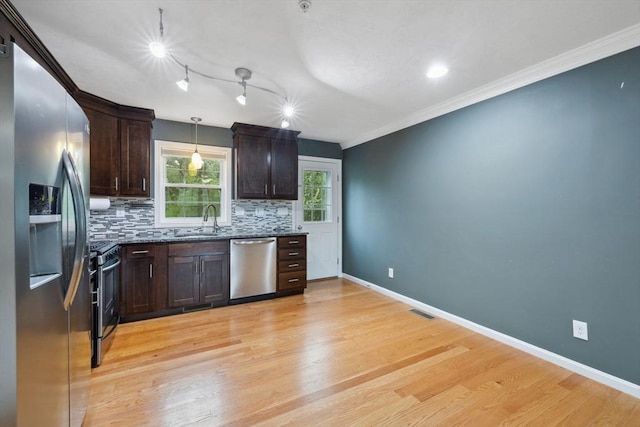 kitchen featuring stainless steel appliances, decorative backsplash, dark brown cabinetry, light wood finished floors, and crown molding