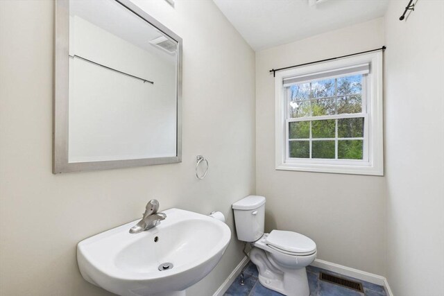 bathroom with a sink, baseboards, and toilet
