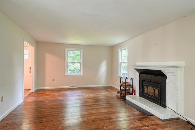 216 Davis St, Northborough, MA 01532 - unfurnished living room featuring healthy amount of natural light, wood finished floors, and a brick fireplace
