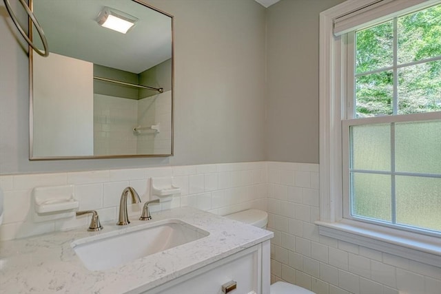 216 Davis St, Northborough, MA 01532 - bathroom with vanity, tile walls, a wainscoted wall, and a shower