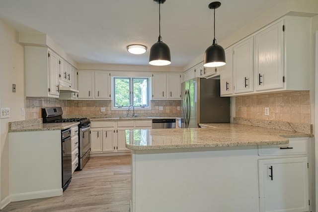216 Davis St, Northborough, MA 01532 - kitchen featuring appliances with stainless steel finishes, under cabinet range hood, a peninsula, light wood-style floors, and white cabinets