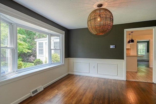 216 Davis St, Northborough, MA 01532 - unfurnished dining area with wood finished floors, a wainscoted wall, and a baseboard radiator