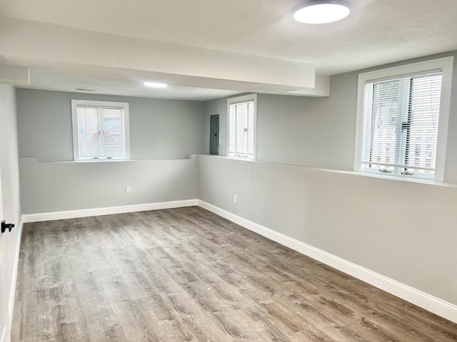 unfurnished room featuring a wealth of natural light, baseboards, and wood finished floors