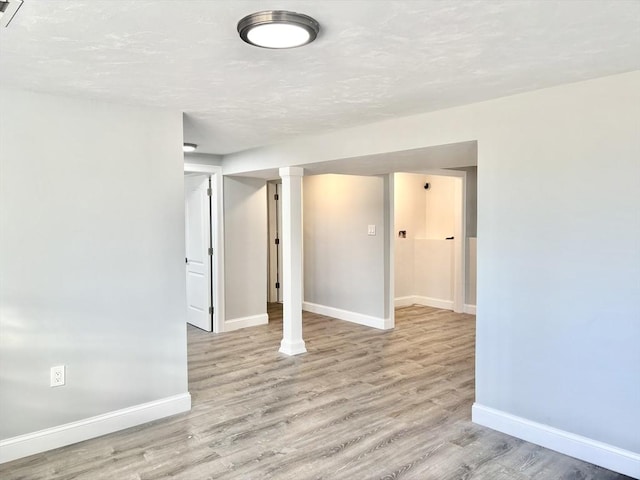 unfurnished room with a textured ceiling, baseboards, and wood finished floors