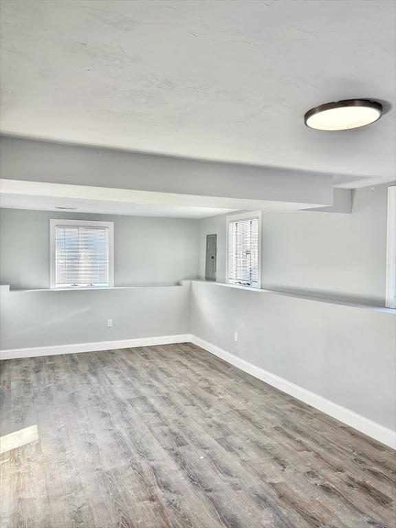 empty room with baseboards and wood finished floors