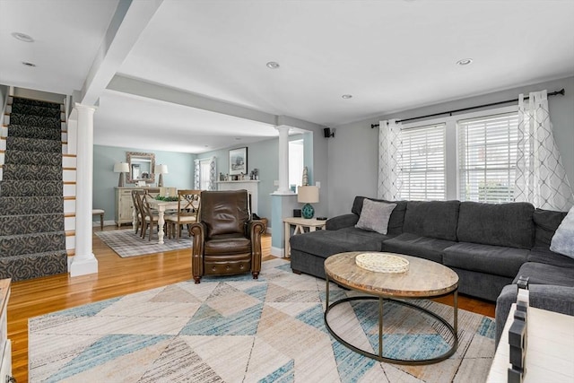 living room featuring light hardwood / wood-style floors and decorative columns