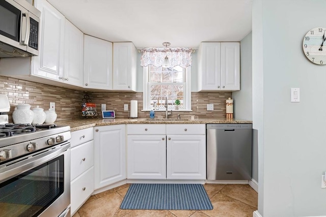 kitchen with tasteful backsplash, sink, white cabinets, light tile patterned floors, and stainless steel appliances