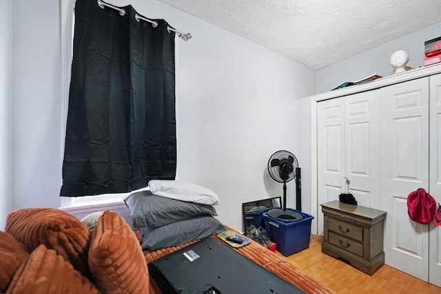 bedroom featuring a closet, a textured ceiling, and light wood-type flooring