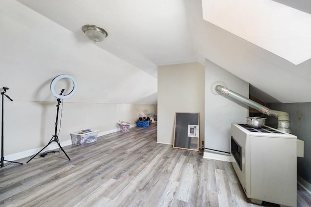 bonus room with lofted ceiling, baseboards, and light wood finished floors