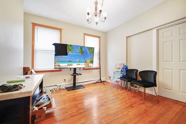 home office with a baseboard radiator, baseboards, a chandelier, and light wood finished floors