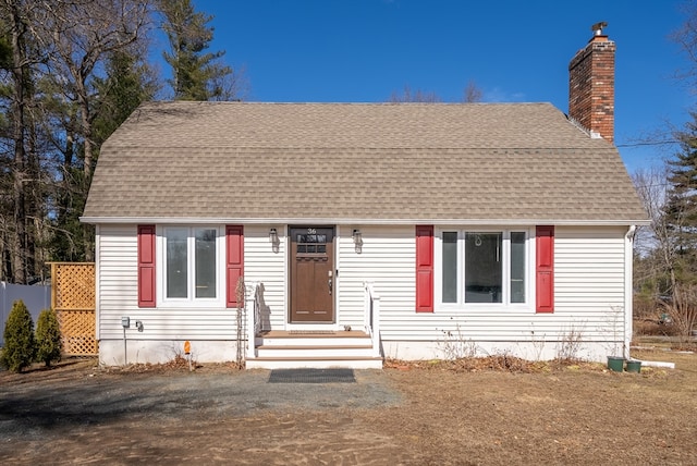 dutch colonial featuring a chimney and a shingled roof