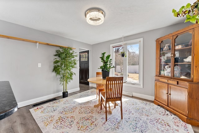 dining area featuring visible vents, baseboards, and light wood-style floors