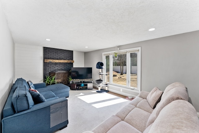 living room featuring recessed lighting, a fireplace, carpet floors, and a textured ceiling