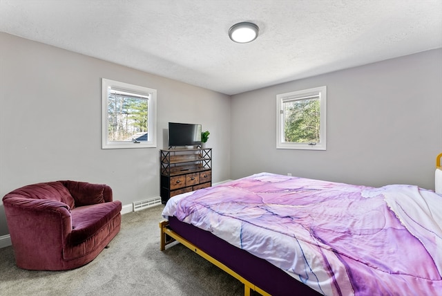 bedroom featuring carpet flooring, a textured ceiling, a baseboard heating unit, and baseboards