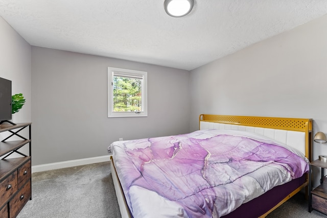 carpeted bedroom featuring a textured ceiling and baseboards