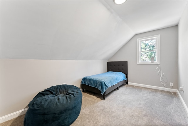 bedroom featuring carpet flooring, lofted ceiling, and baseboards