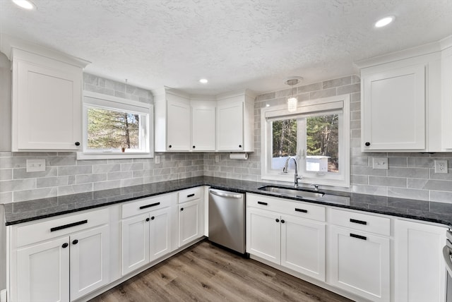 kitchen featuring a sink, dishwasher, light wood-style flooring, and white cabinets