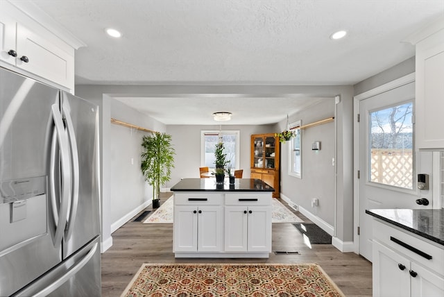 kitchen with stainless steel fridge, plenty of natural light, and wood finished floors