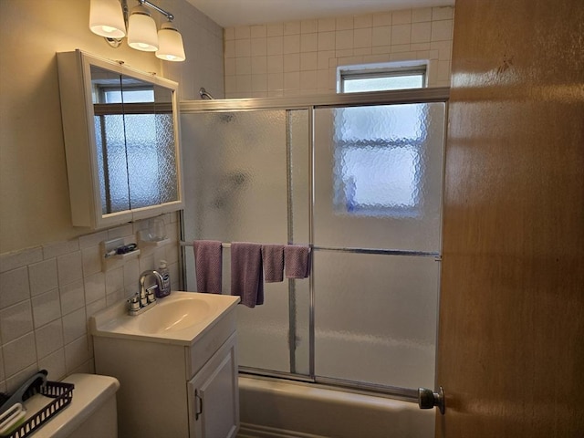82 Lionel Ave Unit B, Waltham, MA 02452 - bathroom featuring vanity, combined bath / shower with glass door, toilet, healthy amount of natural light, and tile walls