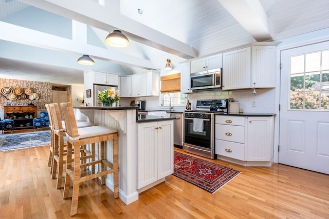 kitchen featuring white cabinets, light wood-type flooring, appliances with stainless steel finishes, and plenty of natural light