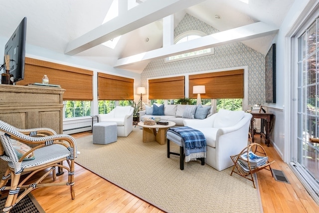 sunroom / solarium featuring lofted ceiling with skylight and a baseboard heating unit