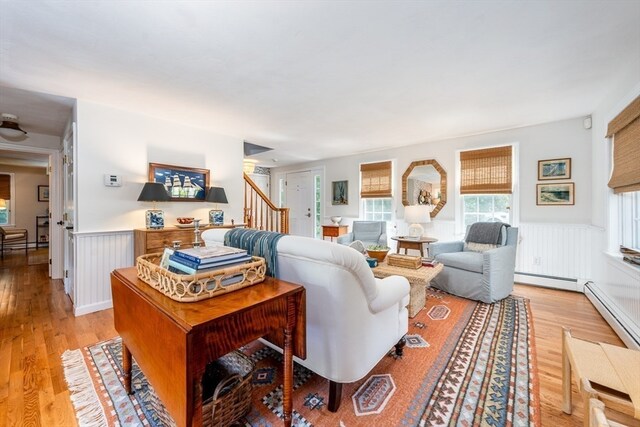 living room featuring a baseboard heating unit and light hardwood / wood-style floors