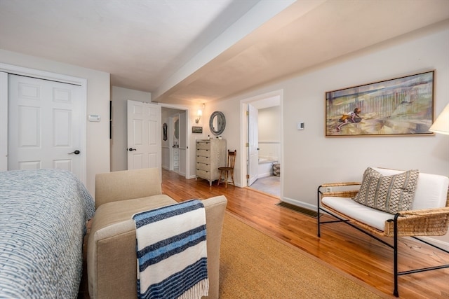 interior space with light hardwood / wood-style flooring, connected bathroom, and a closet