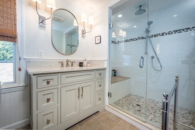 bathroom with tile patterned flooring, a shower with door, and vanity