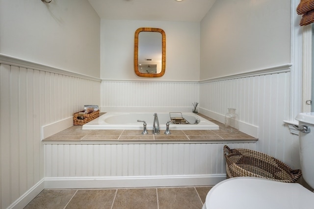 bathroom featuring tile patterned floors, toilet, and a tub