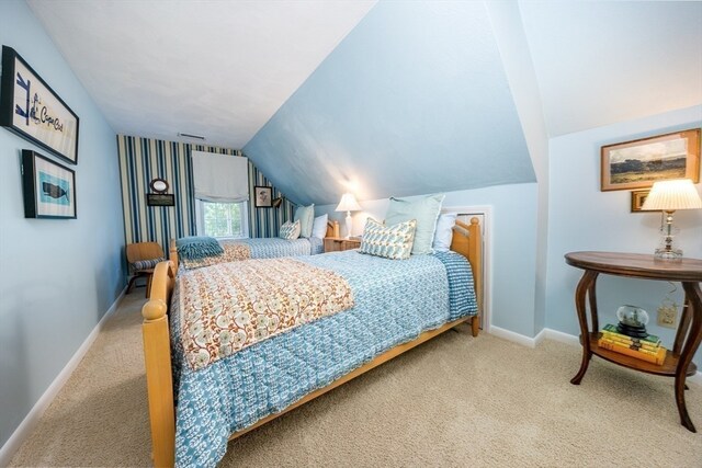 carpeted bedroom with lofted ceiling