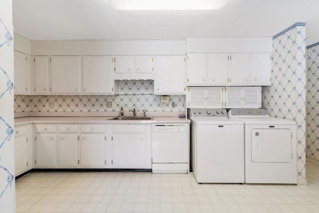 clothes washing area featuring a sink, laundry area, and washer and dryer