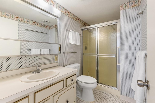 bathroom featuring visible vents, toilet, a shower stall, tile patterned flooring, and vanity