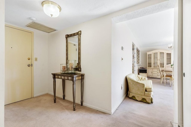 corridor with visible vents, carpet, and baseboards