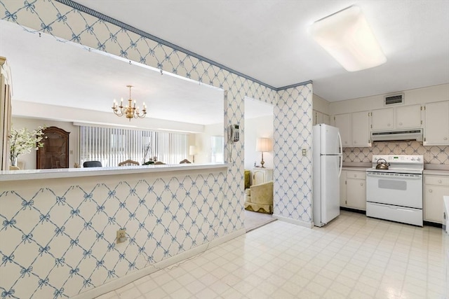 kitchen with white appliances, light floors, visible vents, wallpapered walls, and under cabinet range hood