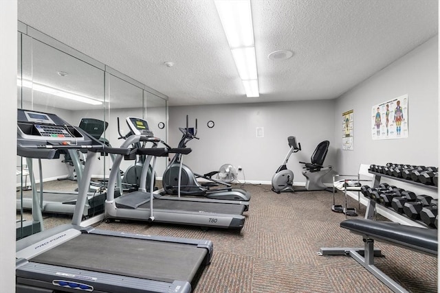 gym with baseboards and a textured ceiling