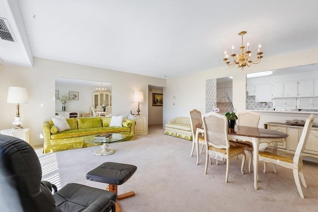 dining space with a notable chandelier, visible vents, and light carpet