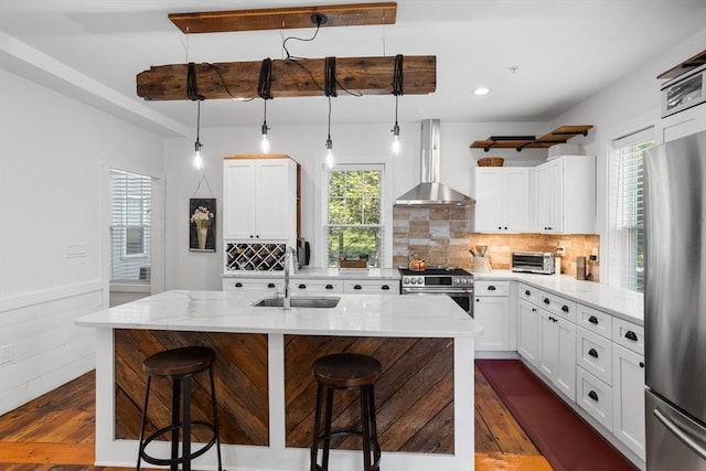 166 Littleton Unit 3, Harvard, MA 01451 - kitchen with wall chimney range hood, appliances with stainless steel finishes, dark wood-style flooring, light stone counters, and wainscoting