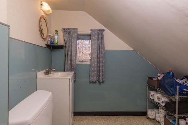 bathroom featuring vanity, toilet, and lofted ceiling