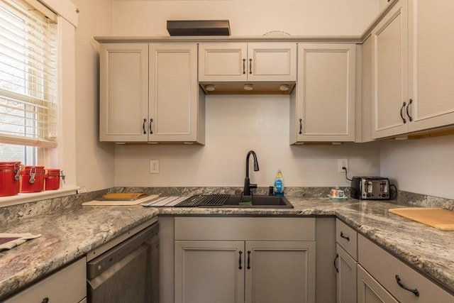 kitchen featuring dishwasher, light stone counters, gray cabinetry, and sink