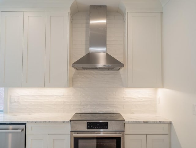182 Merrimac St Unit 1, Newburyport, MA 01950 - kitchen featuring wall chimney exhaust hood, stainless steel appliances, white cabinetry, and tasteful backsplash
