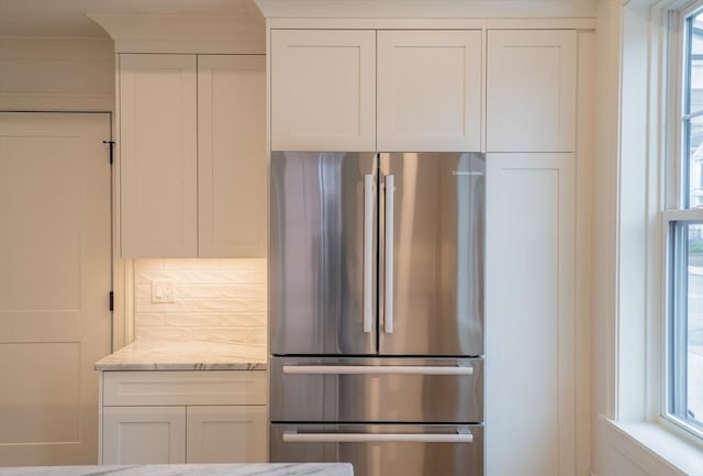 182 Merrimac St Unit 1, Newburyport, MA 01950 - kitchen featuring freestanding refrigerator, white cabinets, light stone countertops, and tasteful backsplash