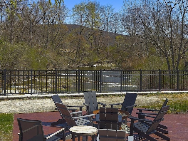 view of patio / terrace featuring a water view and a forest view
