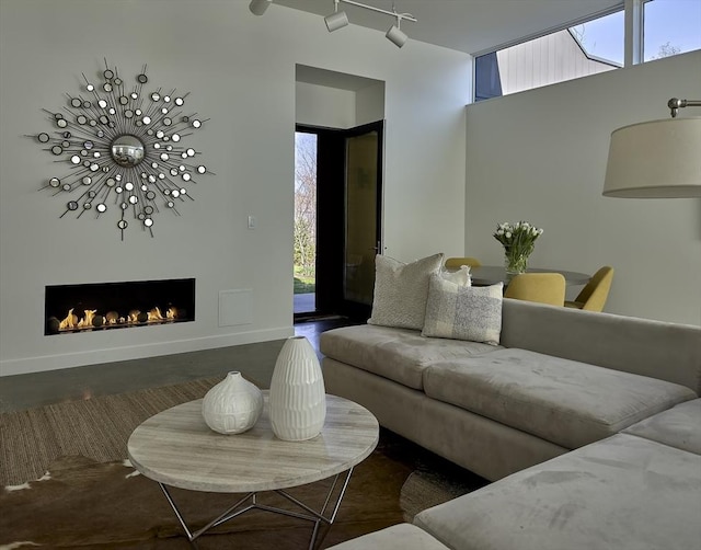 living room featuring track lighting and a warm lit fireplace